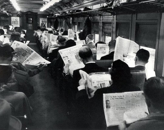 homens lendo jornal dentro do trem 01