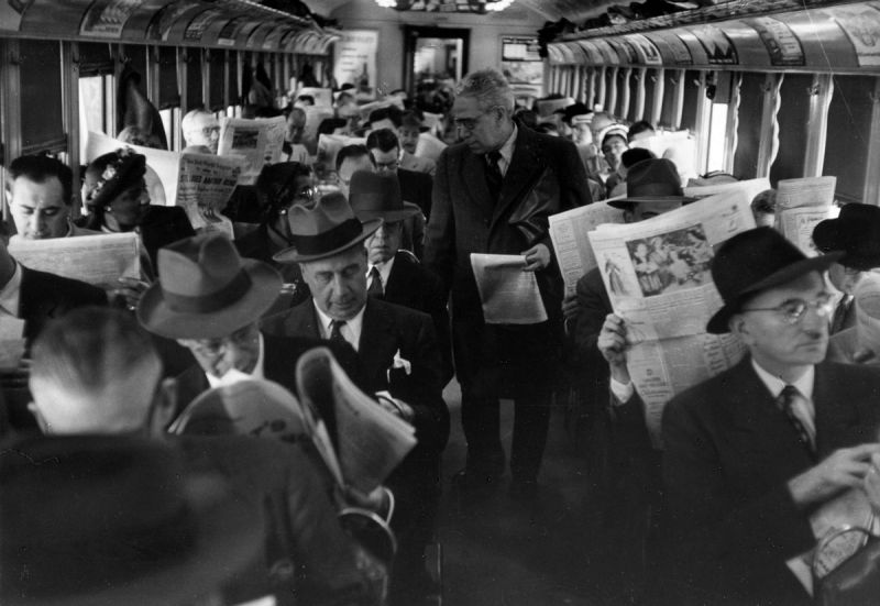homens lendo jornal dentro do trem 02