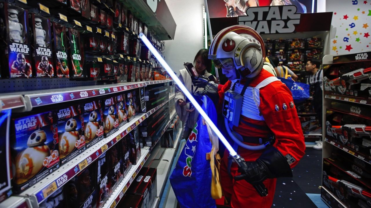 A fan dressed as a Star Wars character shops at a toy store at the midnight in Hong Kong, Friday, Sept. 4, 2015 as part of the global event called "Force Friday" to release new Star Wars toys and other merchandise of the new movie "Star Wars: The Force Awakens". (AP Photo/Kin Cheung)